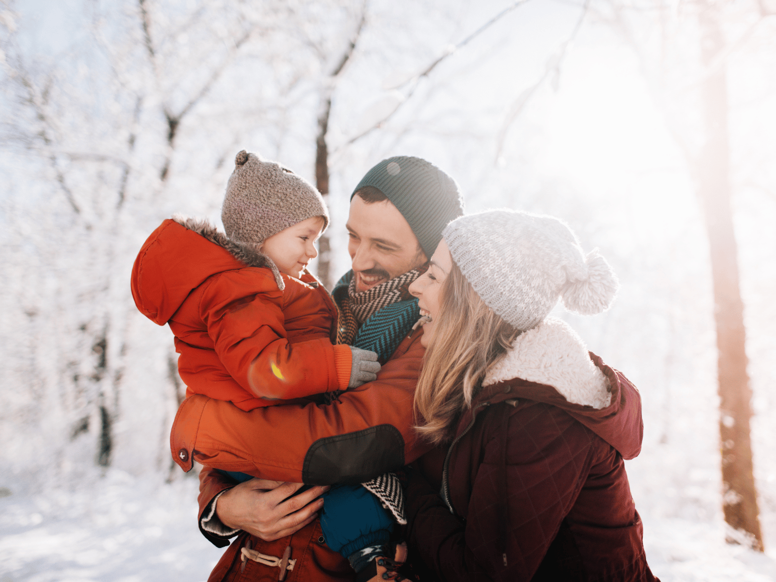 Familie som koser seg i snøen og ler