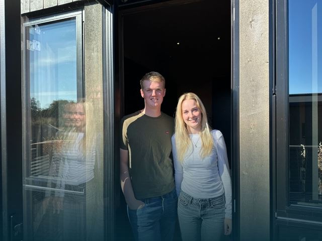 Erik og Miriam som står i verandadøren med gradering over seg.