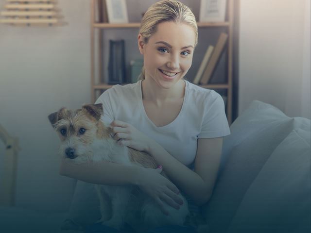 Jente som sitter med hund på fanget