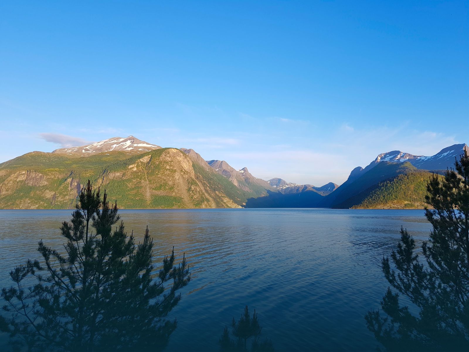 Utsikt mot vannet med fjell og skog